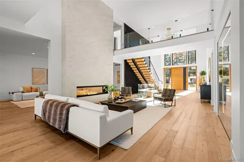 a living room with furniture fireplace and wooden floor