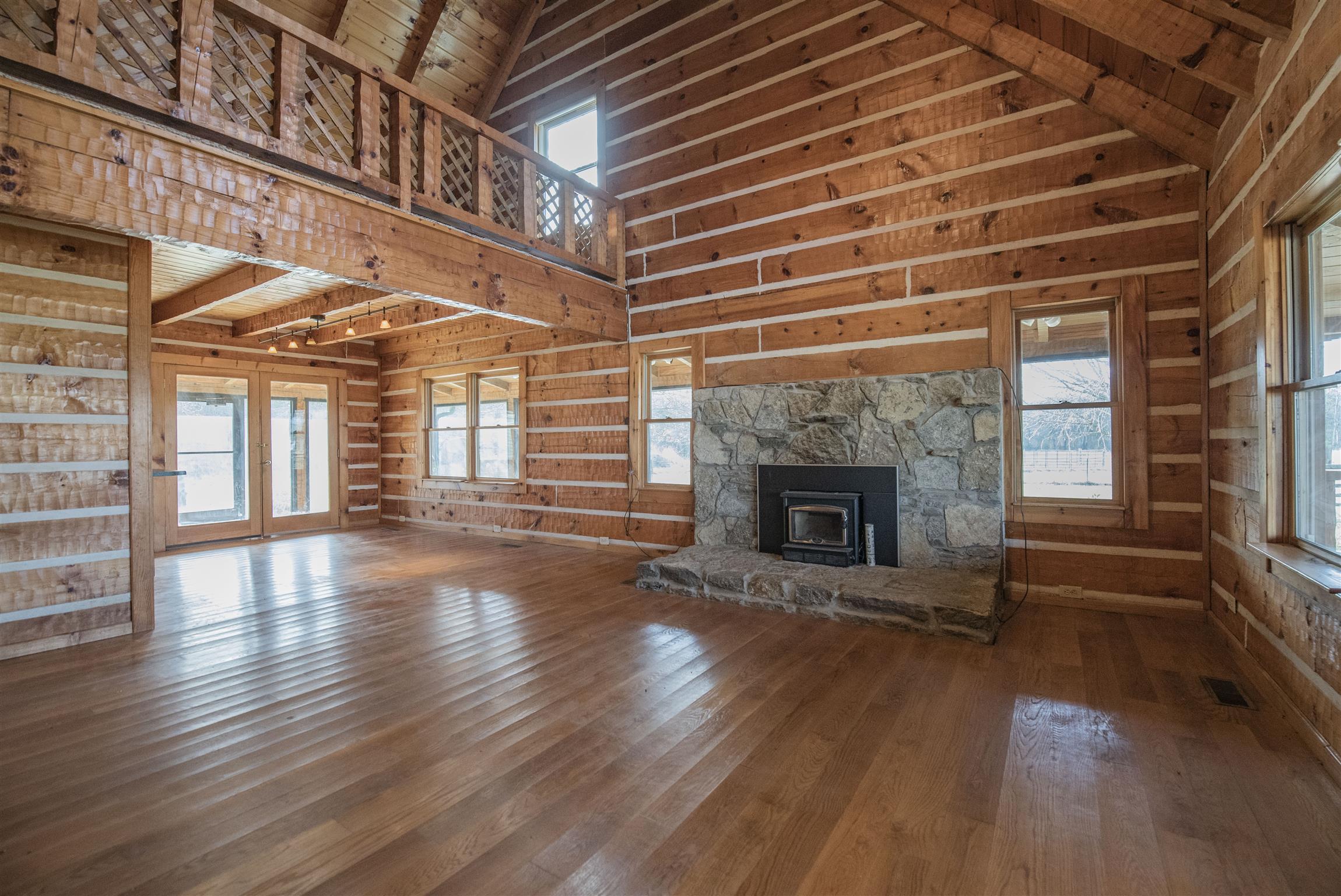 4936 Sledge Road Christiana, TN 37037 - Photo 5 of 30 Living area with soaring ceilings, stone fireplace with modern wood burning insert, hardwood floors and log walls throughout.