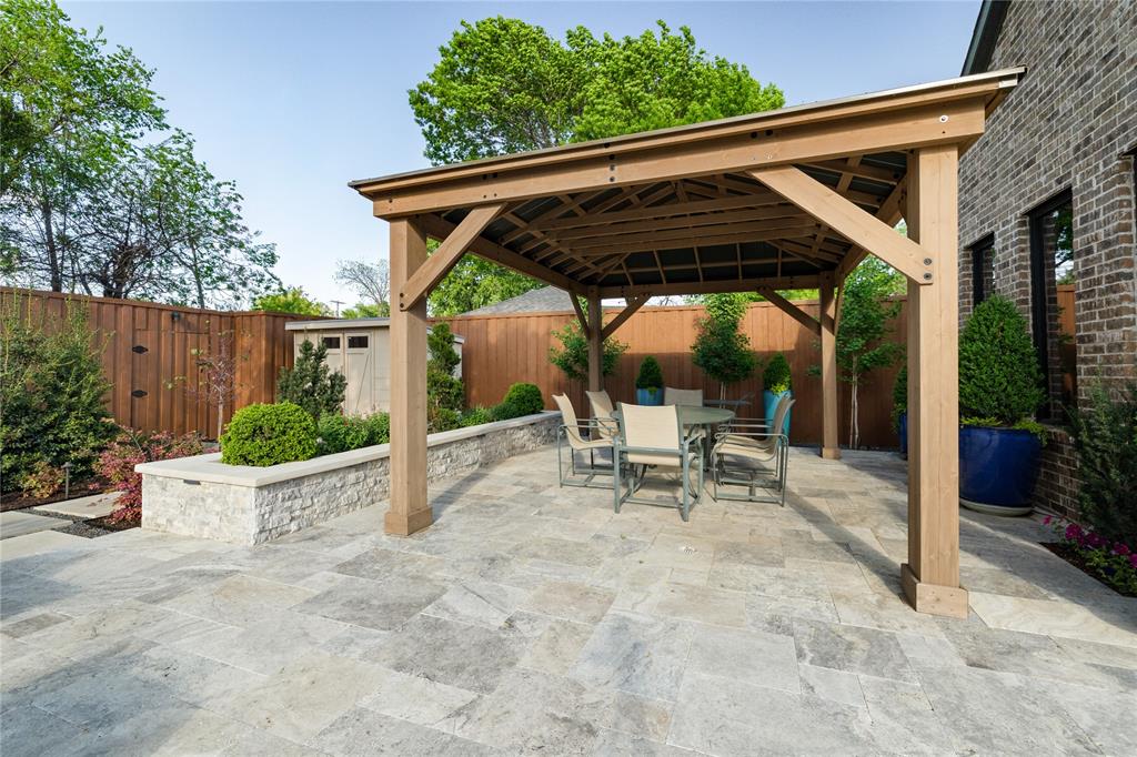 5019 Lark Lane Dallas, TX 75209 - Photo 24 of 32 a view of patio with a table and chairs under an umbrella with a small yard