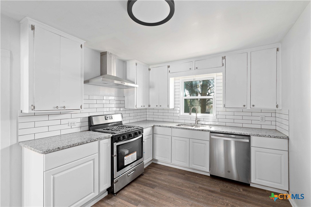 104 East Whitney Street Hamilton, TX 76531 - Photo 12 of 24 a kitchen with stainless steel appliances granite countertop a sink stove and cabinets