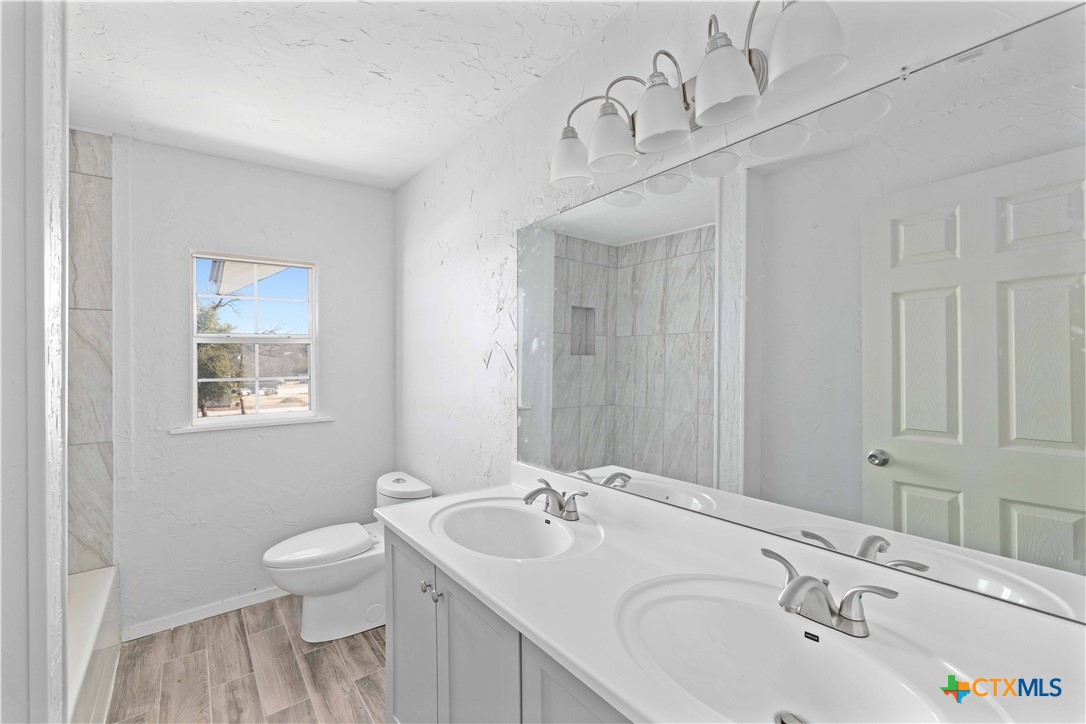 104 East Whitney Street Hamilton, TX 76531 - Photo 6 of 24 a bathroom with a sink and a toilet