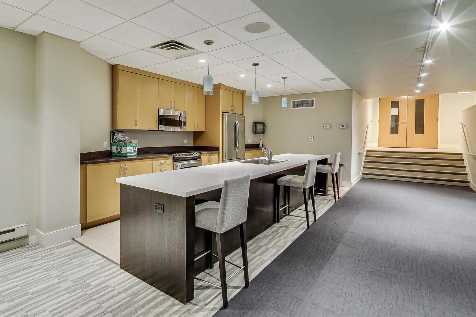 6007 North Sheridan Road, Unit 17DF Chicago, IL 60660 - Photo 16 of 20 a kitchen with stainless steel appliances a stove a sink dishwasher and a refrigerator with wooden floor