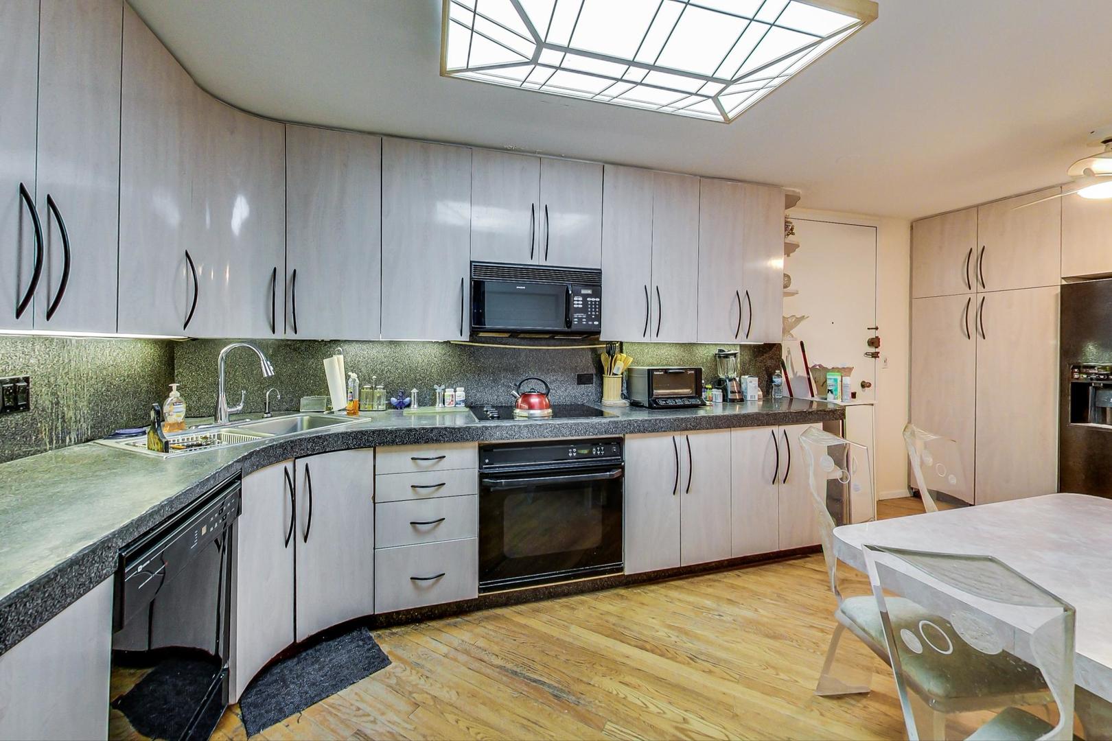6007 North Sheridan Road, Unit 17DF Chicago, IL 60660 - Photo 7 of 20 a kitchen with stainless steel appliances granite countertop a sink a stove a refrigerator and cabinets