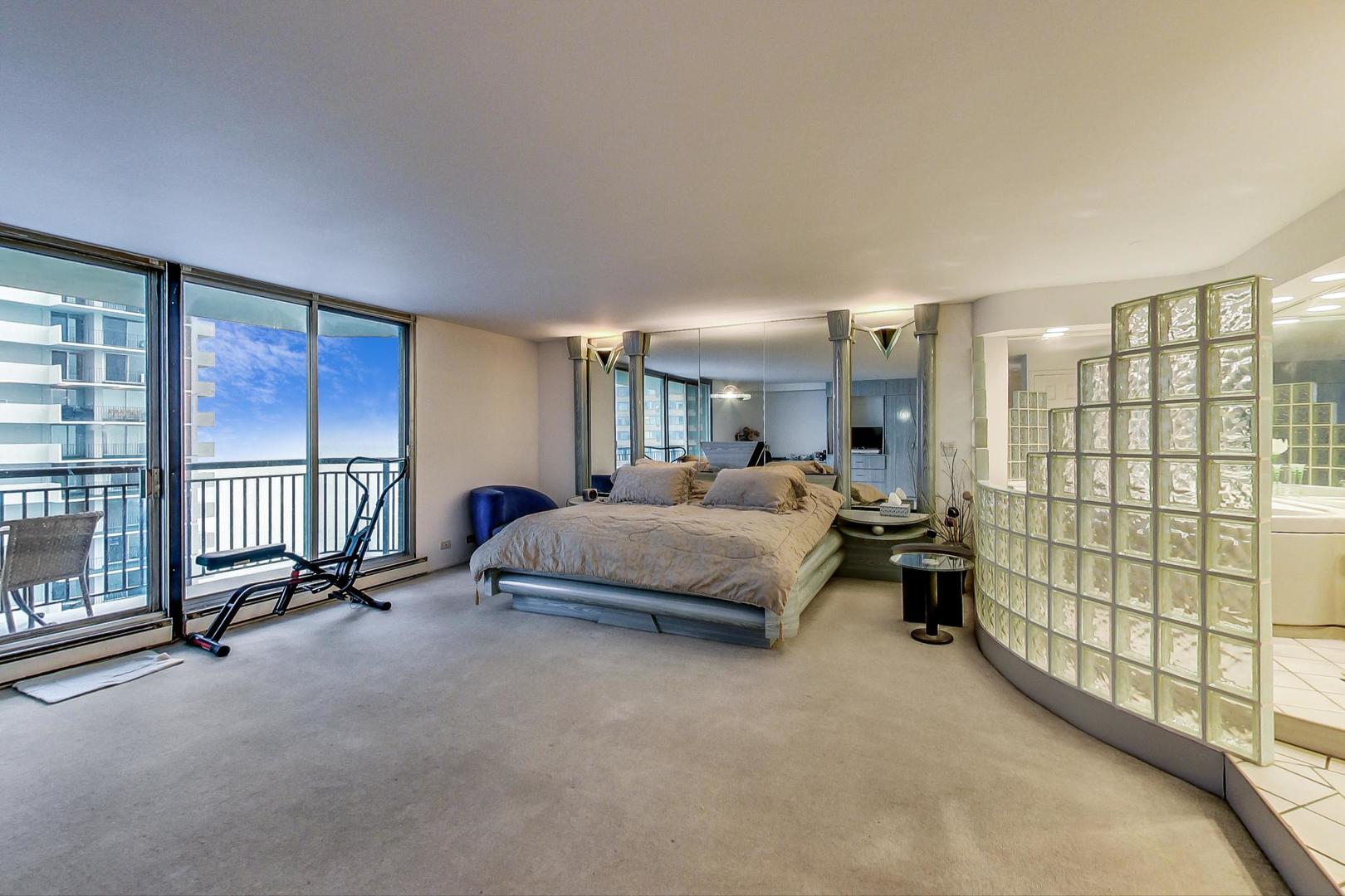 6007 North Sheridan Road, Unit 17DF Chicago, IL 60660 - Photo 8 of 20 a spacious bedroom with a bed and a dresser next to a window