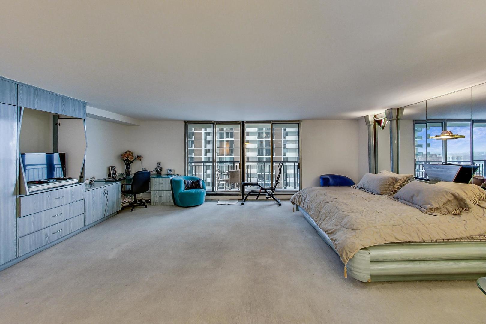 6007 North Sheridan Road, Unit 17DF Chicago, IL 60660 - Photo 10 of 20 a spacious bedroom with a bed and a large mirror