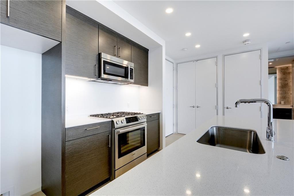301 West Avenue, Unit 1202 Austin, TX 78701 - Photo 4 of 27 a kitchen with stainless steel appliances a stove a microwave and a hard wood floors