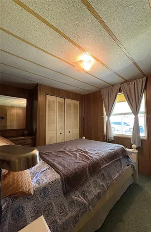 a bedroom with a bed and a large window