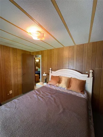 a bed sitting in a spacious bedroom next to a window