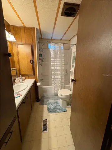 a bathroom with a sink a toilet a mirror and shower