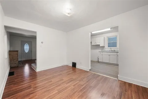 a view of a room with wooden floor and a sink