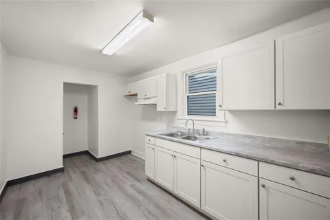 a kitchen with a sink a window and cabinets