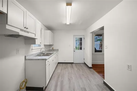 a kitchen with cabinets wooden floor and a sink