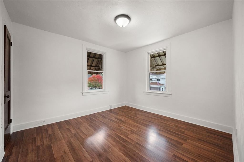1128 9th Street McKees Rocks, PA 15136 - Photo 19 of 33 an empty room with wooden floor and windows
