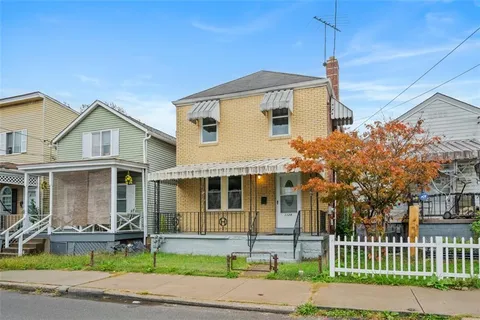 a front view of a house with a yard and table and chairs