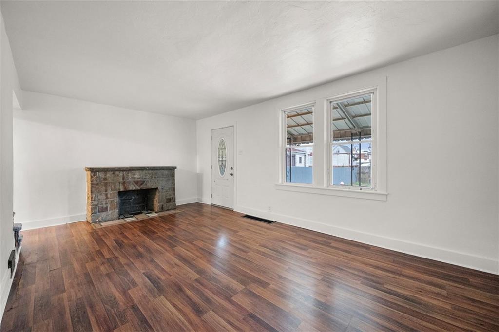 1128 9th Street McKees Rocks, PA 15136 - Photo 6 of 33 an empty room with windows and fireplace