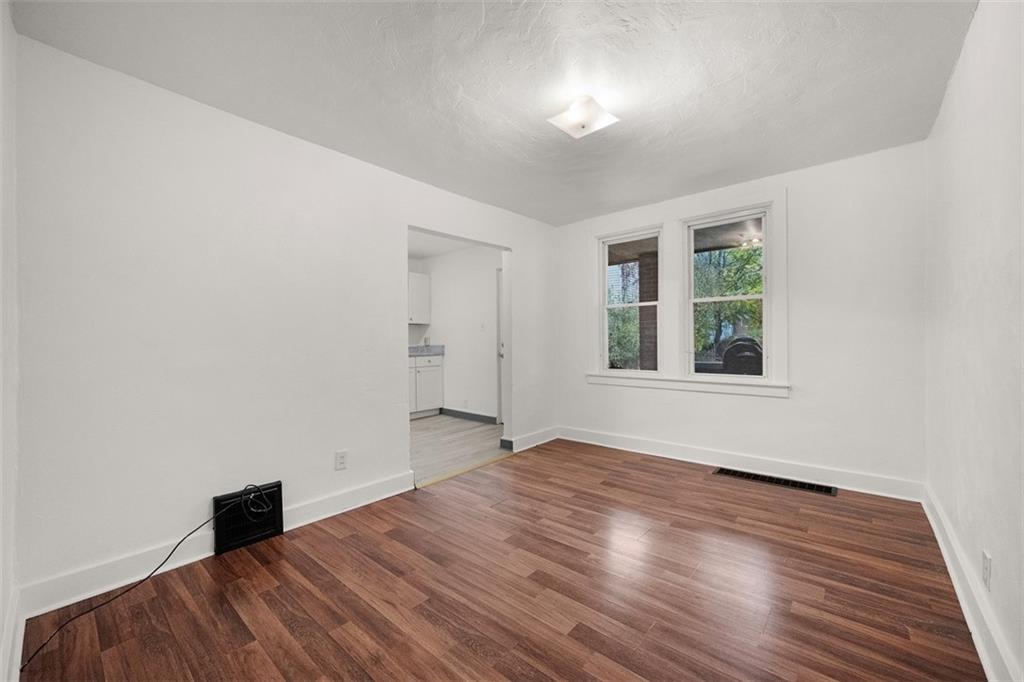 1128 9th Street McKees Rocks, PA 15136 - Photo 10 of 33 wooden floor in an empty room with a window