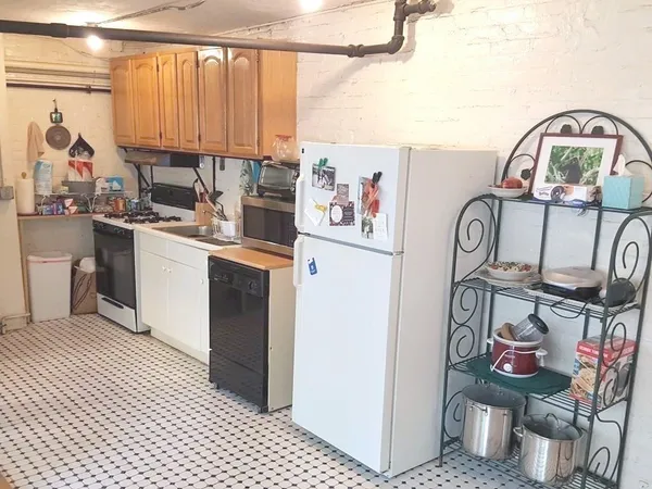 a kitchen with stainless steel appliances granite countertop a stove top oven a sink and a refrigerator