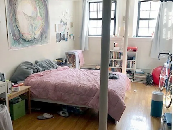 a bed room with a bed and a painting on the wall