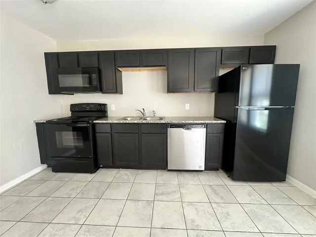 a bathroom with a granite countertop sink a toilet and shower