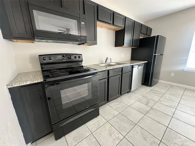 a kitchen with stainless steel appliances a refrigerator sink and microwave