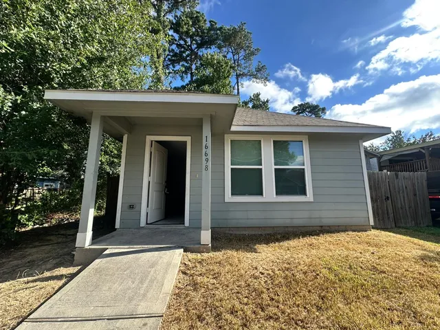 a backyard of a house with plants and tree