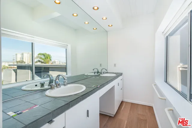a bathroom with a granite countertop sink and a mirror