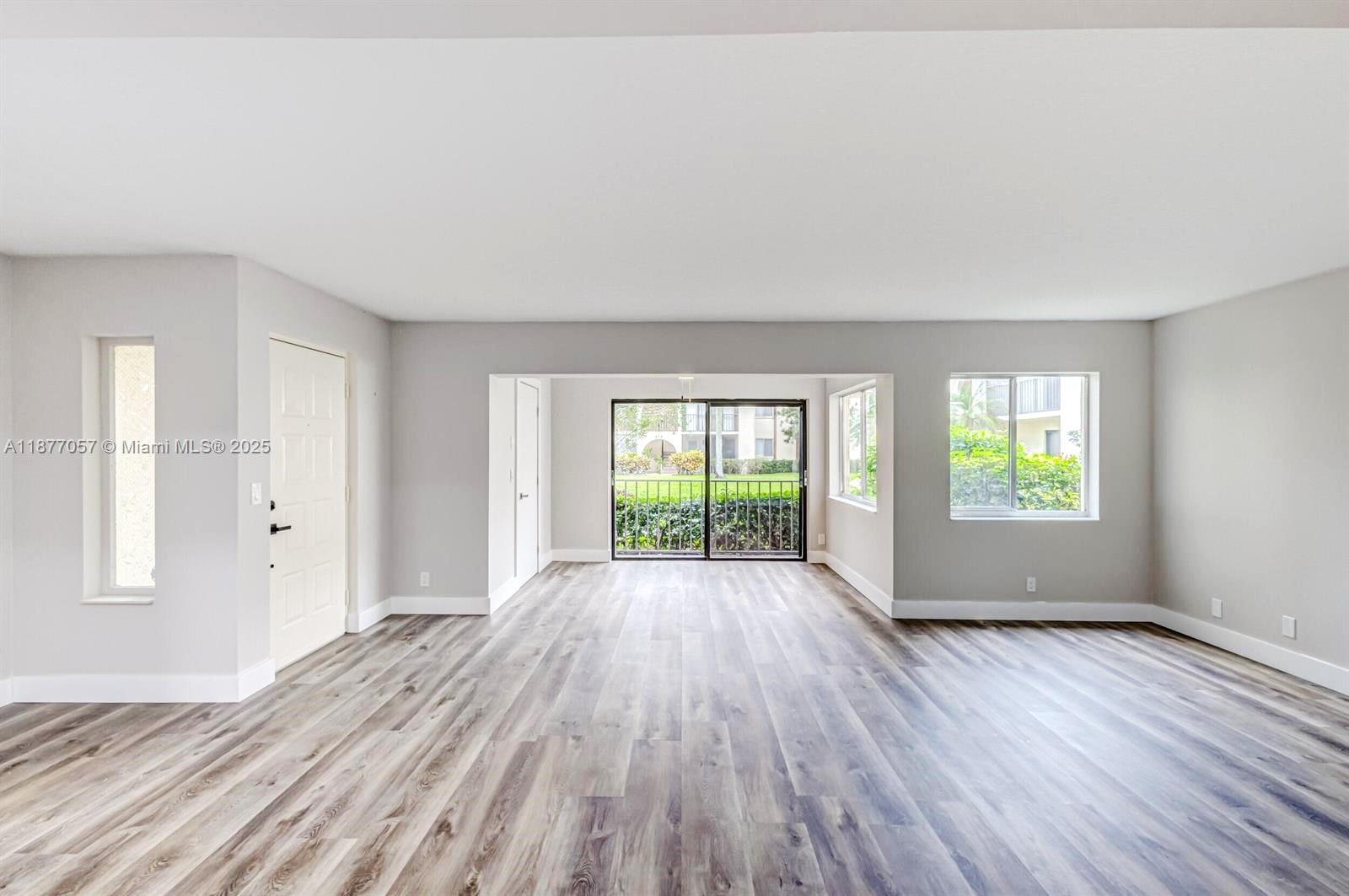 4829 Sable Pine Circle, Unit C1 West Palm Beach, FL 33417 - Photo 6 of 13 an empty room with wooden floor and windows