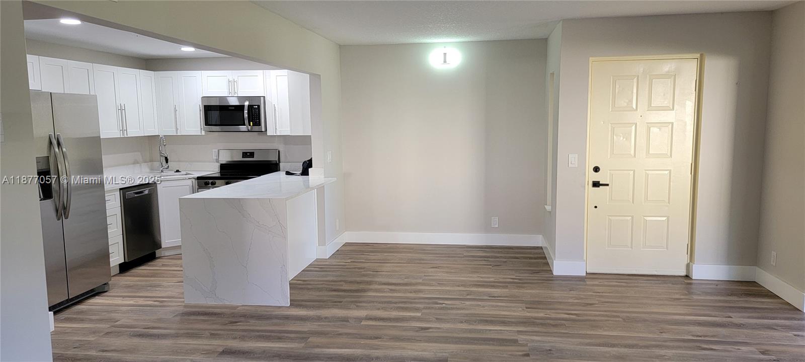 4829 Sable Pine Circle, Unit C1 West Palm Beach, FL 33417 - Photo 9 of 13 a living room with stainless steel appliances kitchen island granite countertop a stove a sink and a refrigerator