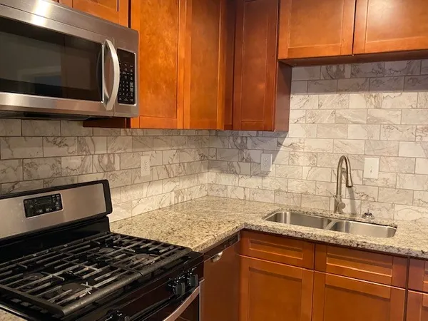 a kitchen with granite countertop stainless steel appliances and cabinets