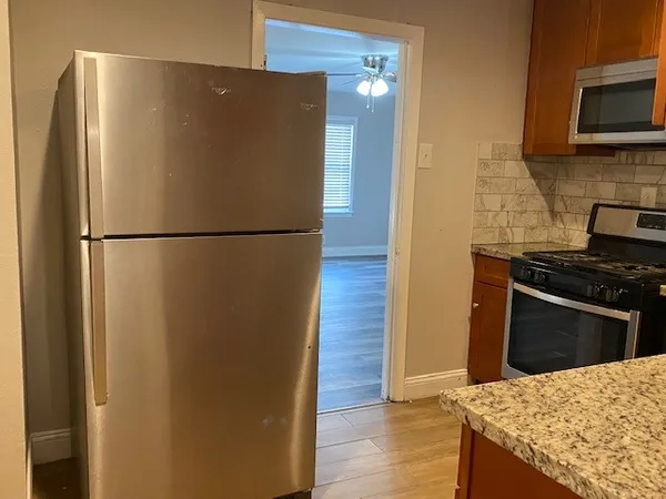 a white refrigerator freezer and a stove sitting inside of a kitchen