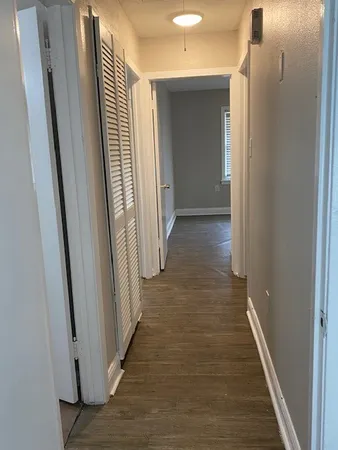 a view of a hallway with wooden floor