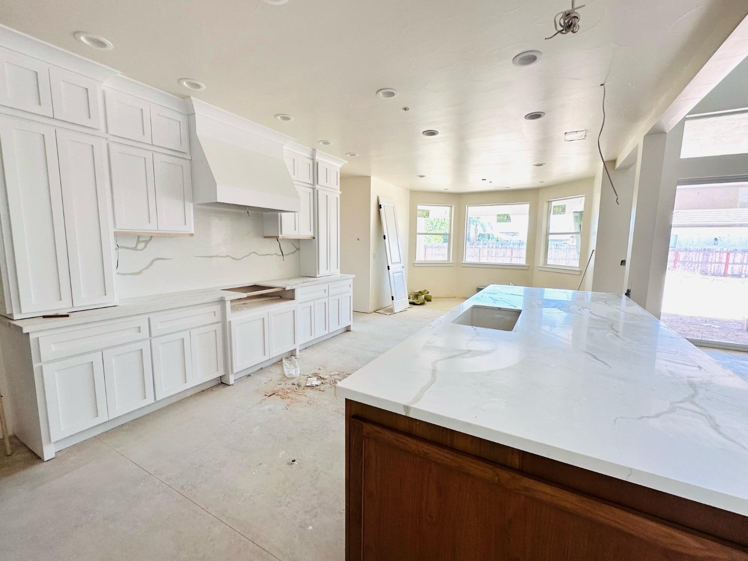 3076 Lester Avenue Clovis, CA 93619 - Photo 12 of 47 a large white kitchen with a sink a window and stainless steel appliances