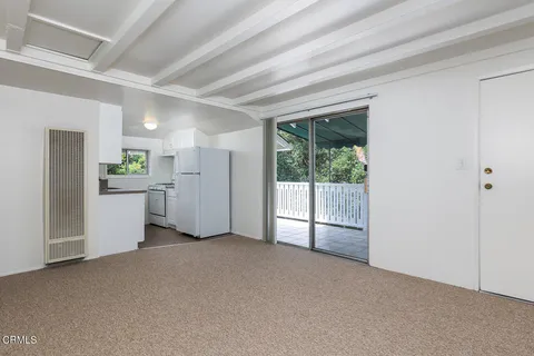 a view of a kitchen with refrigerator and a sink