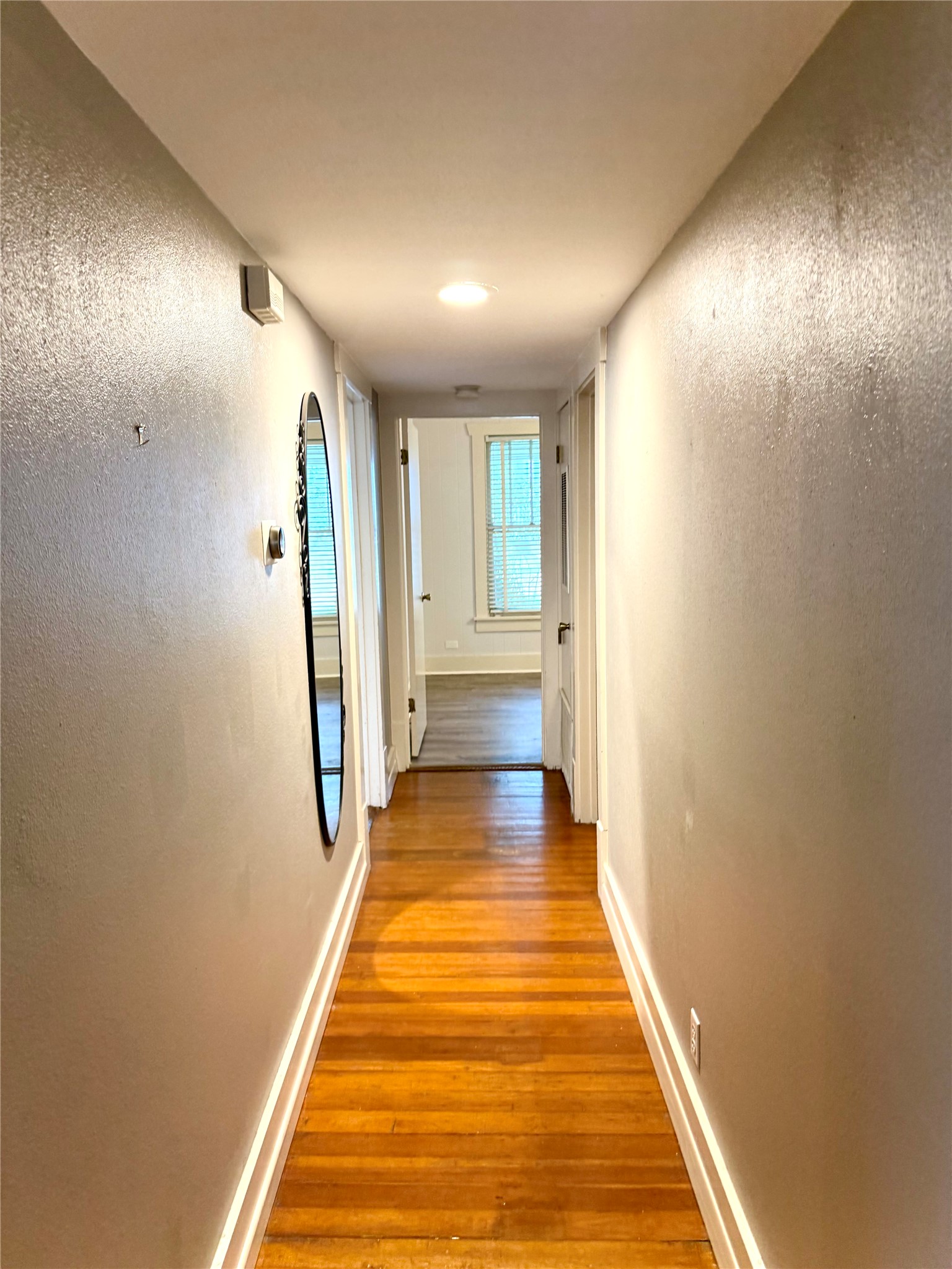 423 South Main Street Lockhart, TX 78644 - Photo 7 of 26 Hallway with warm wood-finish flooring, white baseboards, and recessed ceiling lighting