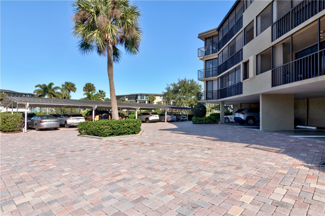 1850 Bay Road, Unit 2C Vero Beach, FL 32963 - Photo 29 of 36 a front view of a building with parking space and palm trees