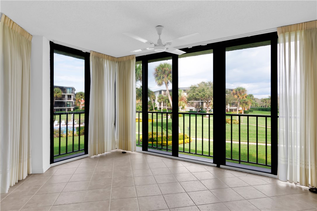 1850 Bay Road, Unit 2C Vero Beach, FL 32963 - Photo 7 of 36 a view of a room with large windows and a ceiling fan