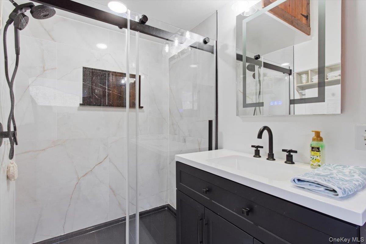 183 Bullet Hole Road Mahopac, NY 10541 - Photo 31 of 44 a bathroom with a sink a large mirror and shower