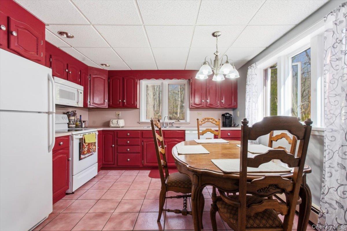 183 Bullet Hole Road Mahopac, NY 10541 - Photo 39 of 44 a kitchen with stainless steel appliances granite countertop a stove a sink dishwasher a dining table and chairs with wooden floor