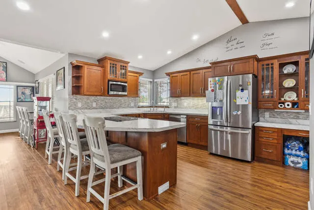 a kitchen with stainless steel appliances granite countertop a refrigerator and wooden cabinets
