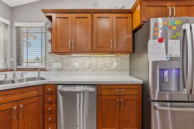 a kitchen with stainless steel appliances granite countertop a refrigerator and a sink