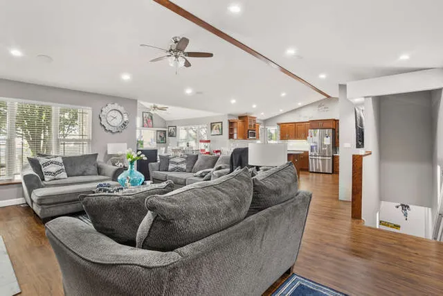a living room with furniture kitchen and wooden floor