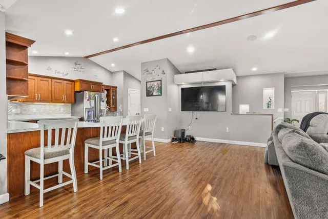 a living room with stainless steel appliances furniture and a flat screen tv