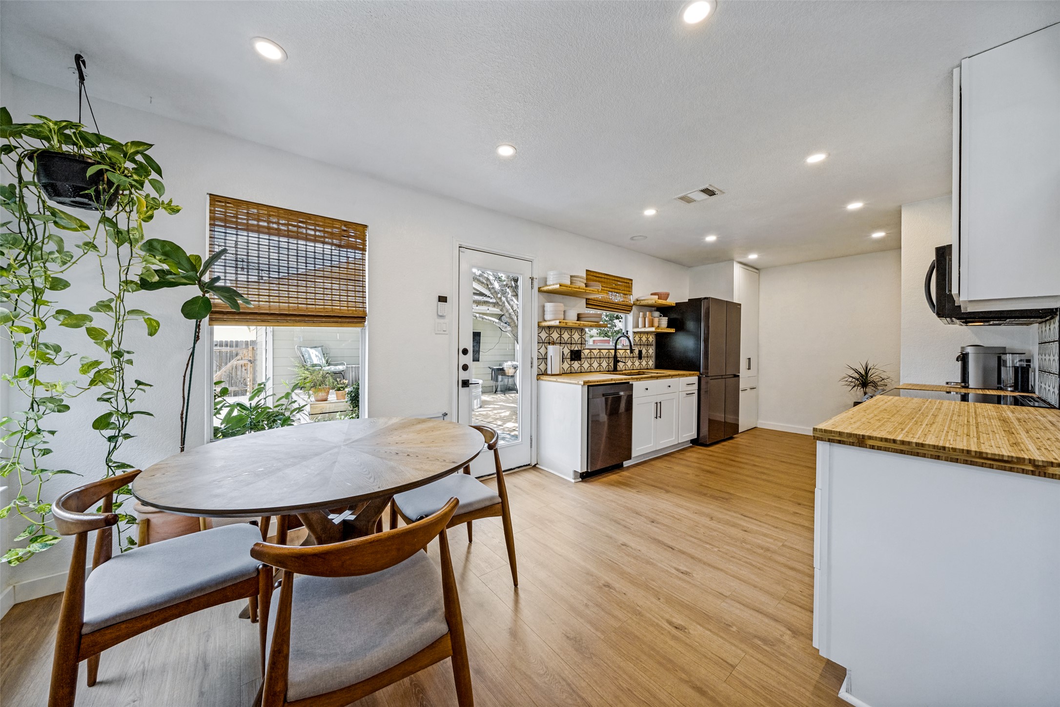 9205 Rowlands Sayle Road Austin, TX 78744 - Photo 7 of 25 A cheerful kitchen with warm wood flooring and a stylish backsplash.