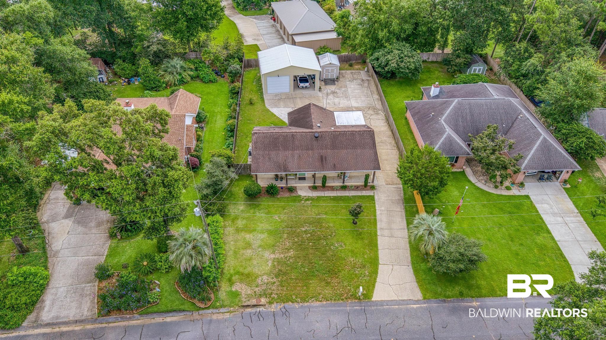 2808 Pine Ridge Drive Lillian, AL 36549 - Photo 5 of 47 Single-story property featuring a front lawn, paved driveway, and established trees
