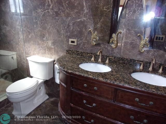 1564 Sunset Way Weston, FL 33327 - Photo 12 of 40 a bathroom with a granite countertop toilet sink and mirror
