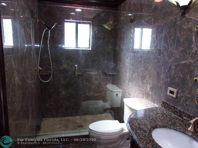 1564 Sunset Way Weston, FL 33327 - Photo 13 of 40 a bathroom with a granite countertop toilet mirror and vanity