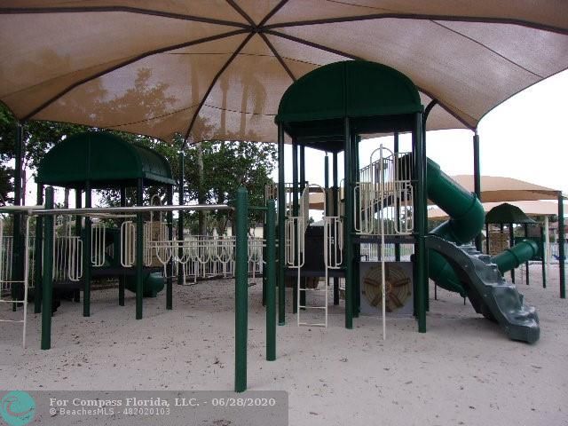 1564 Sunset Way Weston, FL 33327 - Photo 25 of 40 a patio with a table and chairs under an umbrella