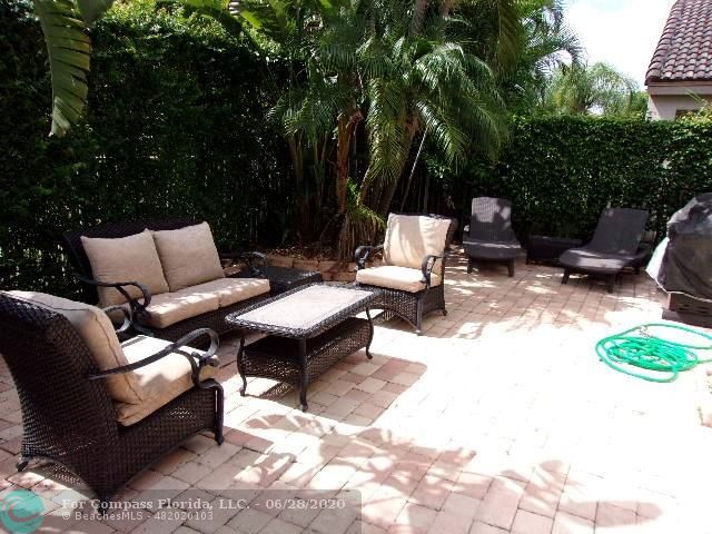 1564 Sunset Way Weston, FL 33327 - Photo 3 of 40 a backyard of a house with table and chairs