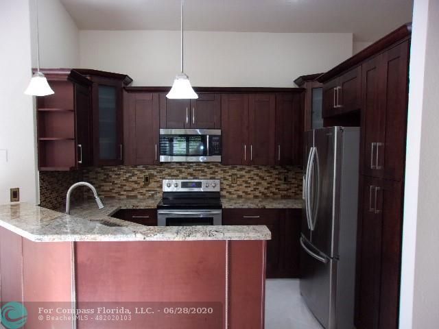1564 Sunset Way Weston, FL 33327 - Photo 34 of 40 a kitchen with stainless steel appliances granite countertop a refrigerator and a sink