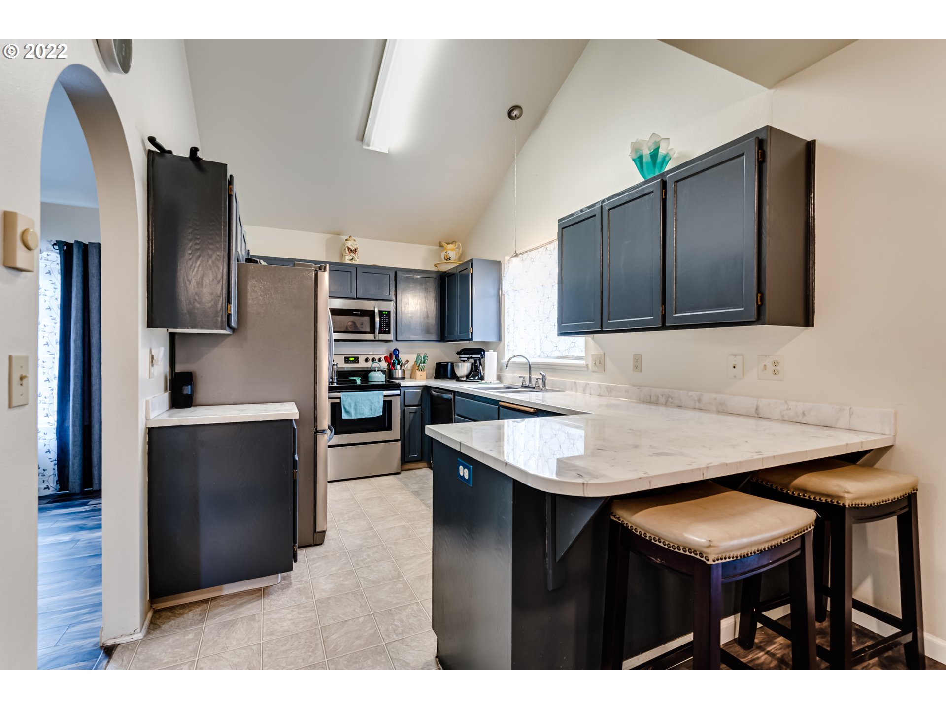 355 South 70th Street Springfield, OR 97478 - Photo 6 of 25 a kitchen with stainless steel appliances kitchen island granite countertop a refrigerator a sink dishwasher a stove with wooden cabinets